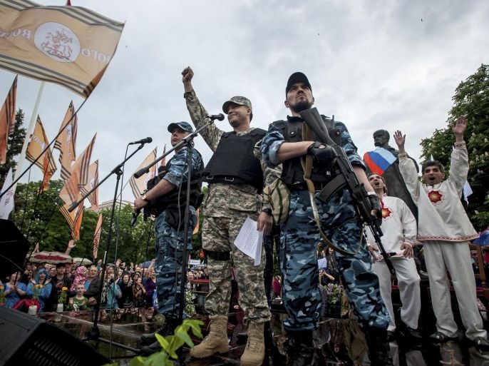 Pro-Russian gunmen and activists react while listening to a speaker as they declare independence for the Luhansk region in eastern Ukraine on Monday, May 12, 2014. Pro-Russia separatists in eastern Ukraine declared independence Monday for the Donetsk and Luhansk regions following their contentious referendum ballot. (AP Photo/Evgeniy Maloletka)