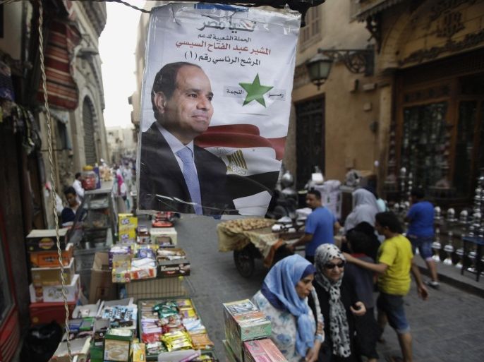 Egyptian shoppers walk under a poster supporting presidential candidate Abdel-Fattah el-Sissi, the country's former military chief, in Cairo, Egypt, Saturday, May 24, 2014. Considered all but certain to win is el-Sissi, the man who removed the former president, Mohammed Morsi. El-Sissi, who for the past 10 months has been the most powerful figure in Egypt, faces one other candidate in the race, leftist politician Hamdeen Sabahi, who finished third in the 2012 presidential election. Arabic reads, "Abdel-Fattah el-Sissi, presidential candidate number 1." (AP Photo/Amr Nabil)