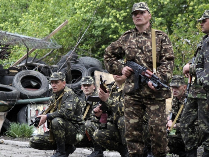 جنود أوكرانيون بوضعية تأهب بماريوبول التي شهدت اشتباكات اليوم (أسوشيتد برس)