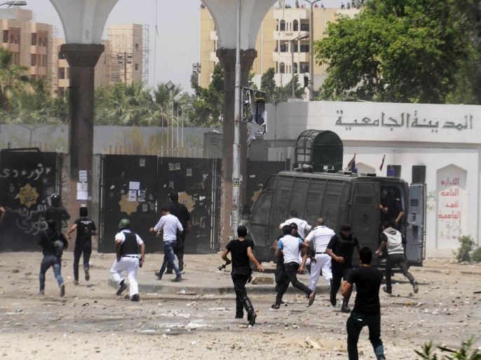 Egyptian security forces run into a student housing area of Al-Azhar University during clashes with student protesters in Cairo, Egypt, Friday, May 16, 2014. Supporters of Egypt's Islamist President Mohammed Morsi continue to protest in the streets as retired Field Marshal Abdel-Fattah el-Sissi, who led last year's overthrow of Morsi, appears poised to win in the presidential election planned this month. (AP Photo/Tarek Wajeh)