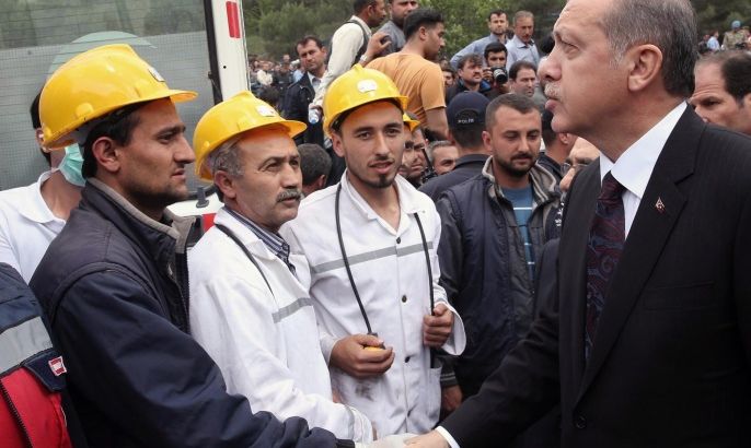 In this photo released by the Turkish Prime Minister's Press Office, Turkish Prime Minister Recep Tayyip Erdogan is surrounded by security members as he visits the coal mine in Soma, Turkey, Wednesday, May 14, 2014. Nearly 450 miners were rescued, the mining company said, but the fate of an unknown number of others remained unclear as bodies are still being brought to the surface and burials are underway after one of the world's deadliest mining disasters. (AP Photo/Kayhan Ozer, Turkish Prime Minister's Press Office, HO)