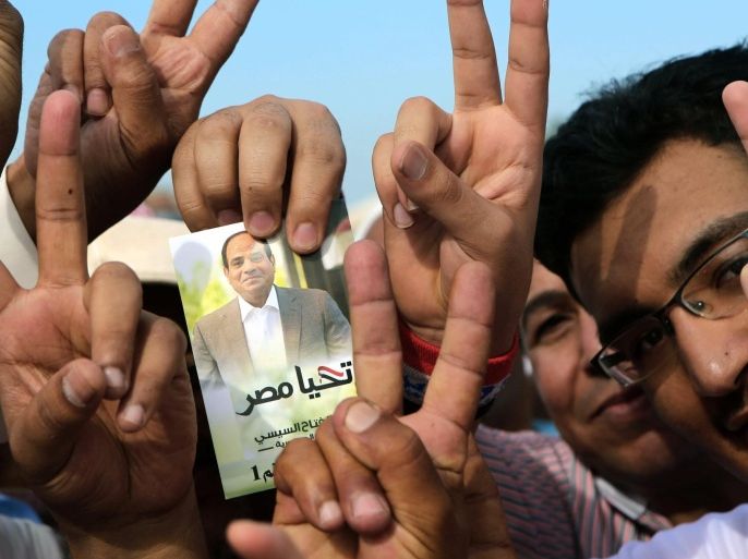 Egyptian expatriates living in Kuwait hold an image of Egypt's ex-army chief and presidential candidate Abdel Fattah al-Sisi, with text reading in Arabic: 'long live Egypt' as they arrive to cast their vote in their country's election at the Egyptian embassy in Kuwait City, on May 16, 2014. Egyptian expatriates around the world headed to the polls, casting the first votes to name a successor to deposed Islamist president Mohamed Morsi. AFP PHOTO / YASSER AL-ZAYYAT
