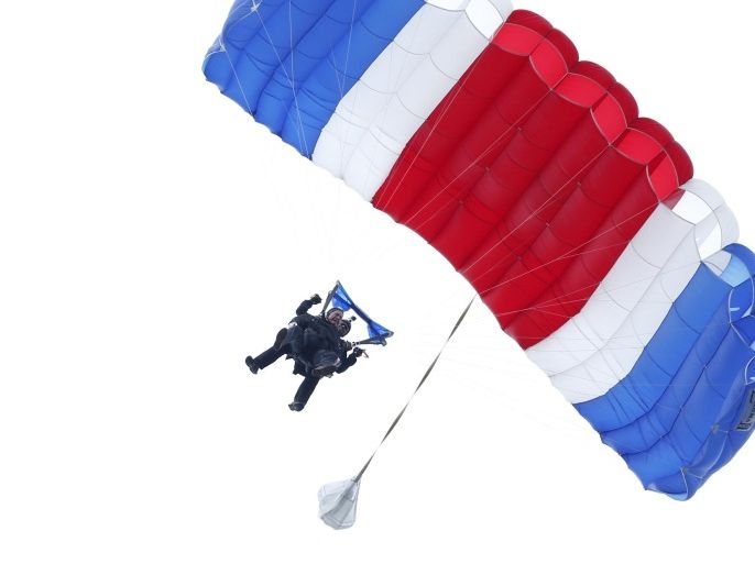 Former President George H.W. Bush, strapped to Sgt. 1st Class Mike Elliott, a retired member of the Army's Golden Knights parachute team, float to the ground during a tandem parachute jump near Bush's summer home in Kennebunkport, Maine, Thursday, June 12, 2014. Bush made the jump, his eighth, in celebration of his 90th birthday. (AP Photo/Robert F. Bukaty)