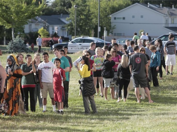 Students and family line up to receive personal property at the north gym of Reynolds Middle School on Tuesday evening, June 10, 2014, in Troutdale, Ore. A teen gunman armed with a rifle shot and killed a 14-year-old student Tuesday and injured a teacher before he likely killed himself at a high school in a quiet Columbia River town in Oregon, authorities said. (AP Photo/The Oregonian, Michael Lloyd)