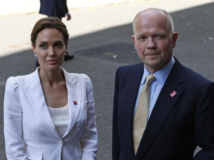 US actress Angelina Jolie, Special Envoy of the United Nations High Commissioner for Refugees, poses for photographers as she arrives with Britain's Foreign Secretary William Hague for their meeting with British Prime Minister David Cameron, at his official residence at 10 Downing Street in central London, Tuesday, June 10, 2014. Hague and Jolie opened the Global Summit to End Sexual Violence in Conflict Tuesday. The Summit will welcome governments from over 100 countries, over 900 experts, NGOs, Faith leaders, and representatives from international organisations across the world. (AP Photo/Lefteris Pitarakis)