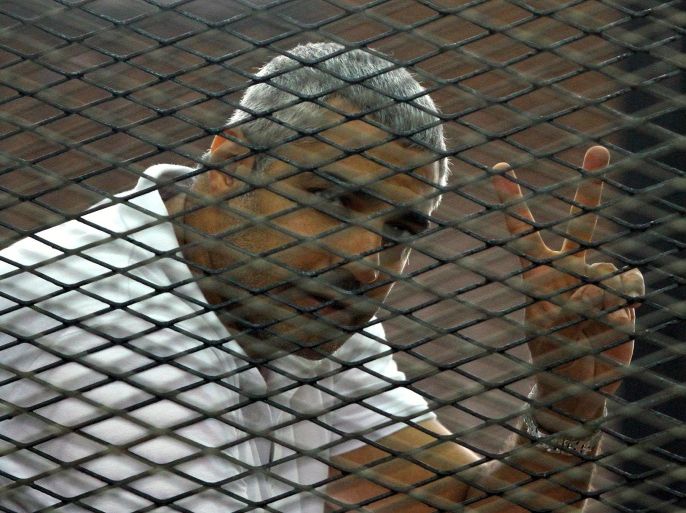Canadian-Egyptian journalist Mohamed Fahmy gestures from the defendant's cage during a sentencing hearing in a courtroom in Cairo, Egypt, Monday, June 23, 2014. An Egyptian court on Monday convicted three journalists from Al-Jazeera English and sentenced them to seven years in prison each on terrorism-related charges, bringing widespread criticism that the verdict was a blow to freedom of expression. The three, Australian Peter Greste, Canadian-Egyptian Mohammed Fahmy and Egyptian Baher Mohammed, have been detained since a December raid on their Cairo hotel room, which they were using as an office as they covered protests by supporters of the ousted Islamist president. The raid was part of a broad crackdown against Islamists and the Muslim Brotherhood.(AP Photo/Ahmed Abd El Latif, El Shorouk Newspaper) EGYPT OUT