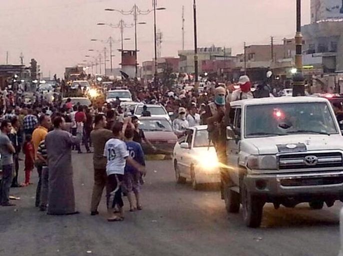 FILE - In this file still image posted on a militant Twitter account on Wednesday, June 11, 2014, which has been authenticated based on its contents and other AP reporting, militants parade down a main road in Mosul, Iraq. Days after Iraq’s second-largest city fell to al-Qaida-inspired fighters, some Iraqis are already returning to Mosul, lured back by insurgents offering cheap gas and food, restoring power and water and removing traffic barricades. (AP Photo/militant source via Twitter, File)