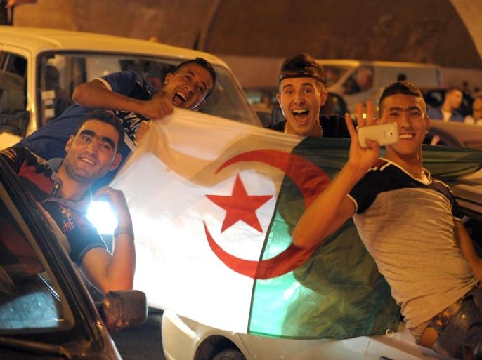In this photo dated Tuesday, June 22, 2014, Algerian soccer fans cheer after their team's World Cup victory over South Korea in Algiers. Algeria won its first World Cup game in 32 years by defeating South Korea 4-2. (AP Photo/Sidali Djarboub)
