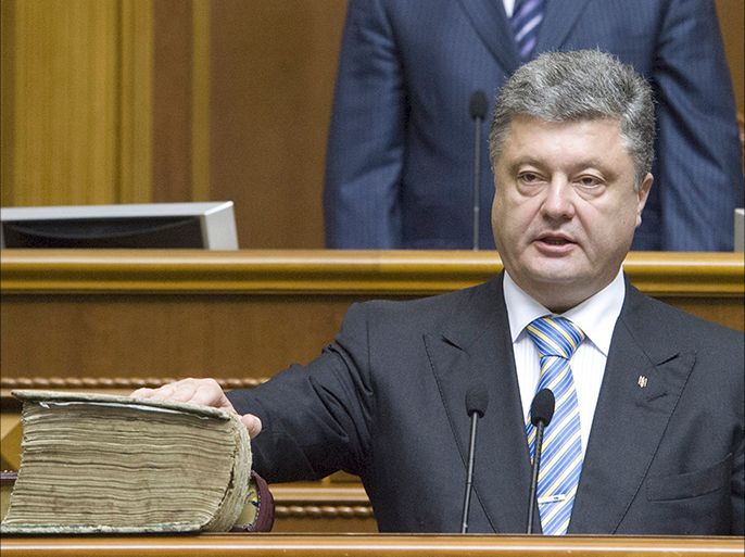 Ukraine's President-elect Petro Poroshenko, holding his hand on the Bible and the constitution, takes the oath of office during his inauguration ceremony in the parliament hall in Kiev June 7, 2014. Poroshenko took the oath on Saturday as