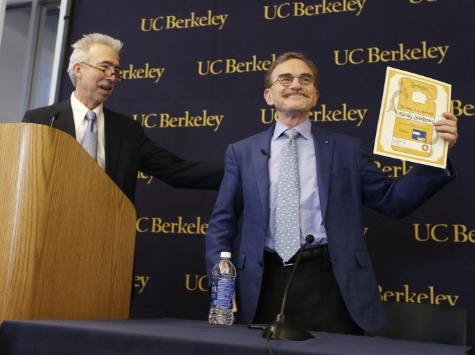 Randy Schekman, right, professor at the University of California, Berkeley, holds up his lifetime campus parking pass that he was given by Chancellor Nicholas Dirks, left, after winning the Nobel Prize in medicine during a news conference Monday, Oct. 7, 2013, in Berkeley, Calif. Two Americans and a German-American won the Nobel Prize in medicine Monday for discovering how key substances are transported within cells, a process involved in such important activities as brain cell communication and the release of insulin. James Rothman, 62, of Yale University, Randy Schekman, 64, of the University of California, Berkeley, and Dr. Thomas Sudhof, 57, of Stanford University shared the $1.2 million prize. (AP Photo/Eric Risberg)