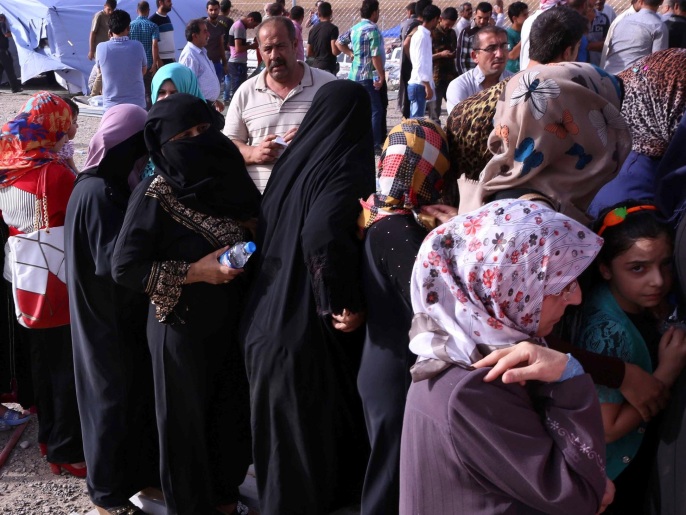 ‪لاجئون من محافظة نينوى بإحدى نقاط التفتيش بإقليم كردستان العراق‬ (غيتي/الفرنسية)
