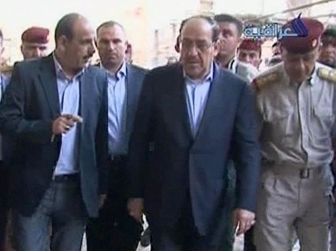 This image made from video broadcast on Al Iraqiya Television on Friday, June 13, 2014 shows Iraqi Prime Minister Nouri al-Maliki, second right, visiting a revered Shiite shrine in Samarra, Iraq. The Iraqi leader moved Friday to try to repair his shattered image after the disastrous loss of the north to Islamic militants. With his job on the line, al-Maliki traveled to Samarra, north of Baghdad, to personally supervise the defense of a city that is home to a revered Shiite shrine against growing attacks. (AP Photo/Al Iraqiya TV via AP video)