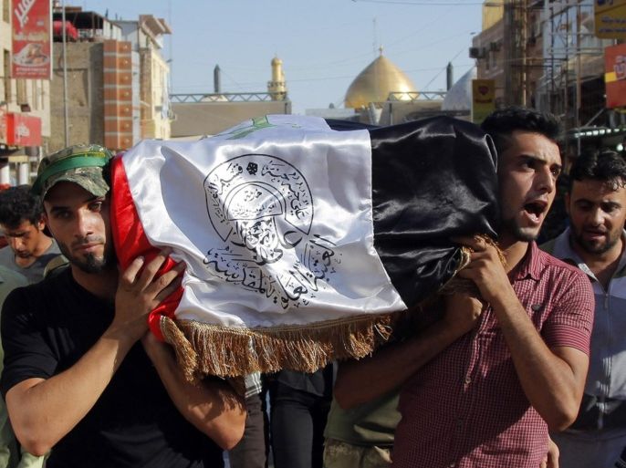 Mourners carry the flag-draped coffin of Abdullah Swadi, a member of an Iraqi volunteer forces group who was killed during clashes with Islamic militants, his family said, during his funeral procession in the Shiite holy city of Najaf, 100 miles (160 kilometers) south of Baghdad, Iraq, Tuesday, July 8, 2014. (AP Photo/Jaber al-Helo)