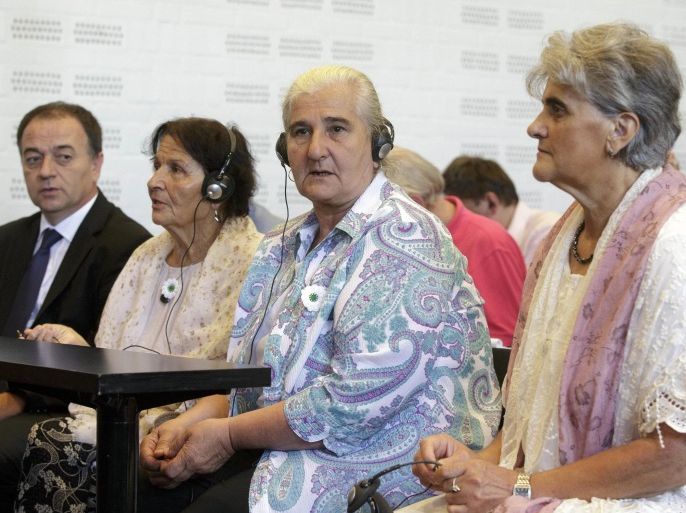 Women from the Bosnian town of Srebrenica wait for judges to enter a civil court in The Hague, Netherlands, Wednesday, July 16, 2014. A court has cleared the Netherlands of liability in the deaths of the vast majority of the 8,000 Bosnian Muslims slain in the Srebrenica massacre 19 years ago, but says it has to compensate the families of more than 300 men turned over to Bosnian Serb forces and later killed. The decision was a victory for only a fraction of the families of men and boys slain in the July 1995 Srebrenica massacre in Bosnia. In an emotionally charged hearing judges said Dutch U.N. peacekeepers should have known that more than 300 men deported from the Dutch compound by Bosnian Serb forces on July 13, 1995, would be slain. (AP Photo/Phil Nijhuis)