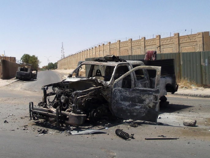 ‪سيارة تابعة للشرطة العراقية دمرت خلال القتال مع المسلحين في تكريت‬ (أسوشيتد برس)