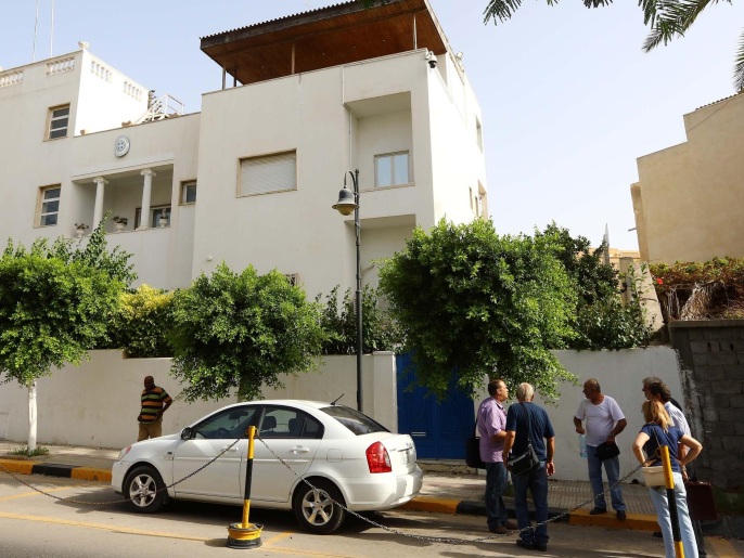 مواطنون يونانيون ينتظرون أمام مقر سفارة بلادهم بطرابلس لإجلائهم من ليبيا (الفرنسية)