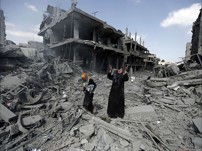 A Palestinian woman pauses amid destroyed buildings in the northern district of Beit Hanun in the Gaza Strip during an humanitarian truce on July 26, 2014. The bodies of at least another 35 Palestinians were recovered from rubble across Gaza during a truce, raising to over 900 the overall death toll of Israel's onslaught on the territory since July 8, medics said. AFP PHOTO / MOHAMMED ABED