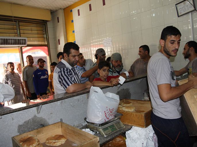 مواطنون يصطفون لشراء الخبز في أحد مخابز خانيونس