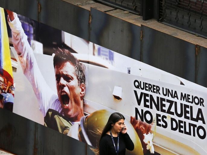 A woman walks past a banner with a picture of jailed opposition leader Leopoldo Lopez in Caracas July 23, 2014. The trial of Lopez is scheduled to start on July 23. The banner reads "Wanting a better Venezuela is not a crime". REUTERS/Jorge Silva (VENEZUELA - Tags: POLITICS CRIME LAW SOCIETY)