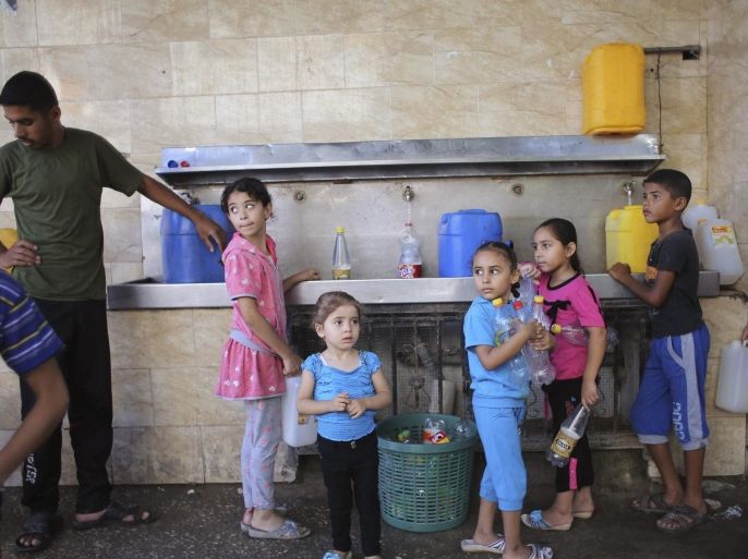 Palestinian children fill bottles and containers with water from a public tap in Rafah in the southern Gaza Strip July 17, 2014. Palestinians rushed to shops and banks on Thursday during a five-hour humanitarian ceasefire that largely held, and an Israeli official said Egypt had proposed a permanent truce that would start on Friday. Gaza health officials say at least 224 Palestinians, mostly civilians, have been killed in 10 days of warfare between the Islamist Hamas rulers of Gaza and Israel. In Israel, one civilian has been killed by fire from Gaza, where the Israeli military says more than 1,300 rockets have been launched into the Jewish state. REUTERS/Ibraheem Abu Mustafa (GAZA - Tags: POLITICS CIVIL UNREST CONFLICT TPX IMAGES OF THE DAY)