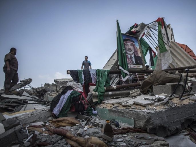 A picture of senior Hamas figure and former Prime Minister of the Gaza Strip, Ismail Haniye, is standing amidst the rubble of his house, which was destroyed in an overnight Israeli airstrike in Gaza City, 29 July 2014.