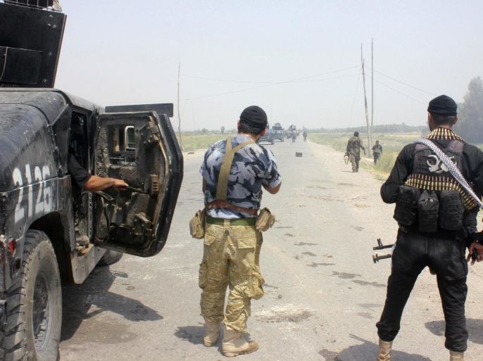Iraqi security forces and armed volunteers move with military vehicles during clashes with militants of the Islamic State, formerly known as the Islamic State in Iraq and the Levant (ISIL), in the town of Dalli Abbas in Diyala province July 3, 2014. The al Qaeda splinter group leading the insurgency has declared a medieval-style Islamic caliphate erasing the borders of Iraq and Syria, and threatened to march on the Iraqi capital Baghdad to topple the Shi'ite-led central government. Picture taken July 3, 2014. REUTERS/Stringer (IRAQ - Tags: CIVIL UNREST POLITICS MILITARY)