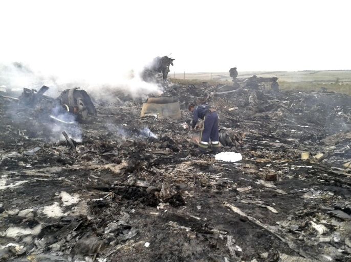 An Emergencies Ministry member works at the site of a Malaysia Airlines Boeing 777 plane crash in the settlement of Grabovo in the Donetsk region, July 17, 2014. The Malaysian airliner was shot down over eastern Ukraine by pro-Russian militants on Thursday, killing all 295 people aboard, a Ukrainian interior ministry official said. REUTERS/Maxim Zmeyev (UKRAINE - Tags: TRANSPORT DISASTER)