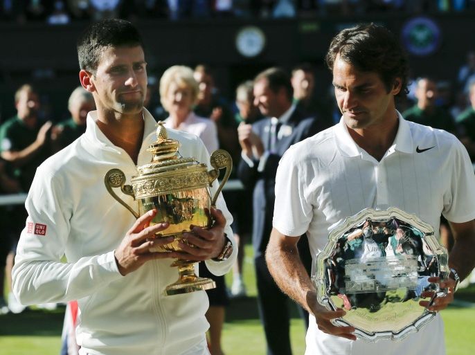 Serbia's Novak Djokovic, left, holds his trophy after defeating Switzerland's Roger Federer, right, in the men's singles final match at the All England Lawn Tennis Championships in Wimbledon, London, Sunday, July 6, 2014. (AP Photo/Ben Curtis)