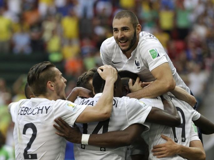 France's Karim Benzema, top, celebrates with teammates after Paul Pogba, right, hidden by players, scored their side's first goal during the World Cup round of 16 soccer match between France and Nigeria at the Estadio Nacional in Brasilia, Brazil, Monday, June 30, 2014. (AP Photo/Ricardo Mazalan)