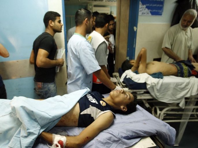 A Palestinian whom medics said was wounded in an Israeli air strike, lies on a bed at a hospital in Gaza City July 8, 2014. At least 14 people were killed in strikes on the Gaza Strip on Tuesday, Palestinian officials said, as Israel threatened a lengthy offensive against militants whose rocket fire reached as far as Tel Aviv. REUTERS/Ahmed Zakot (GAZA - Tags: POLITICS CIVIL UNREST CONFLICT)