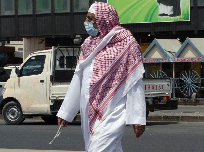 A Sausi man wears a mouth and nose mask as he walks in a street of the Red Sea coastal city of Jeddah on April 27, 2014. The MERS death toll in Saudi Arabia neared 100 this weekend as the authorities scrambled to reassure an increasingly edgy population in the country worst-hit by the infectious coronavirus. AFP PHOTO/STR