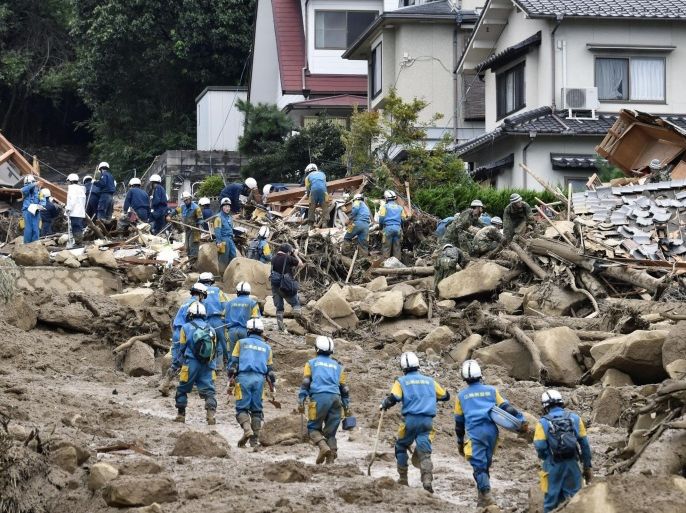 Rescue workers search for survivors after a massive landslide swept through residential areas in Hiroshima, western Japan, Wednesday, Aug. 20, 2014. Rain-sodden slopes collapsed in torrents of mud, rock and debris early Wednesday in the outskirts of Hiroshima, killing at least 36 people, police said. (AP Photo/Kyodo News) JAPAN OUT, MANDATORY CREDIT