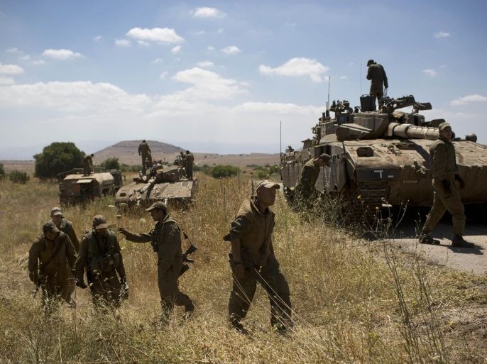Israeli soldiers work on their tanks following the first death on the Israeli side of the Golan since the Syrian civil war erupted more than three years ago, near the Israeli village of Alonei Habashan, in the area of Tel Hazeka, close to the Quneitra border crossing in the Israeli-controlled Golan Heights, Sunday, June 22, 2014. A civilian vehicle in the Israeli-controlled Golan Heights was targeted by forces in neighboring Syria on Sunday in an attack that killed a 15-year-old boy and prompted Israeli tanks to retaliate by firing on Syrian government targets, the Israeli military said. (AP Photo/Oded Balilty)