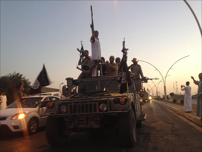 ‪مقاتلون من تنظيم الدولة الإسلامية يجوبون شوارع الموصل شمالي العراق‬ (أسوشيتد برس)
