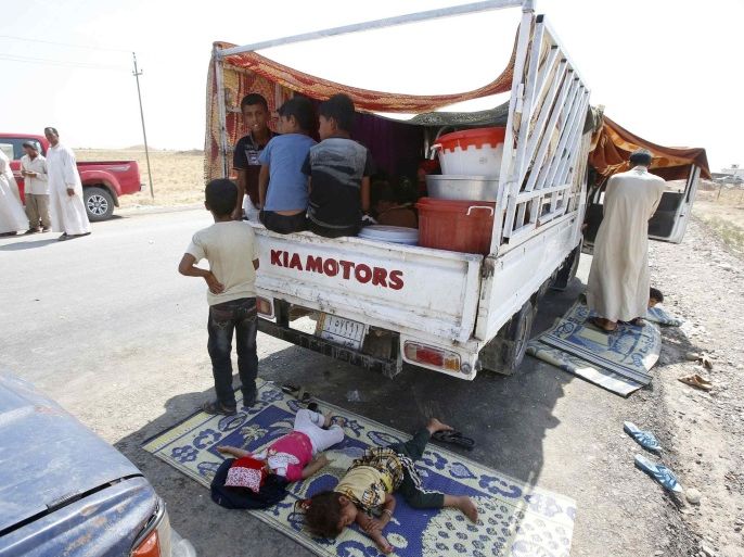 Displaced people from the minority Yazidi sect, who fled the violence in the Iraqi town of Gwer, wait to return at a check point at the entrance of Gwer August 18, 2014. REUTERS/Youssef Boudlal (IRAQ - Tags: CIVIL UNREST POLITICS MILITARY)