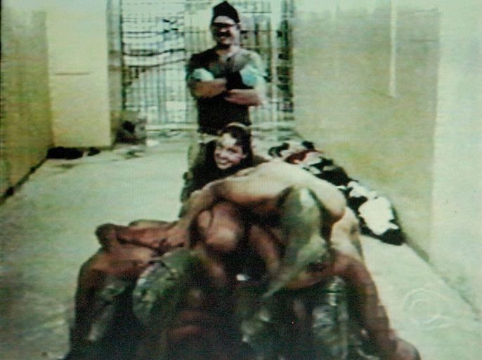 RETRANSMISSION FOR QUALITY An image of Iraqi prisoners in Abu Ghraib prison in Bhagdad allegedly seated on top of other prisioners while nude and their heads covered with hoods as an unidentified United States military personel stand in proximity. The photo was first seen on the CBS television program Sixty Minutes II aired on Wednesday 28 April 2004 and was altered due to the content. EPA/DSK