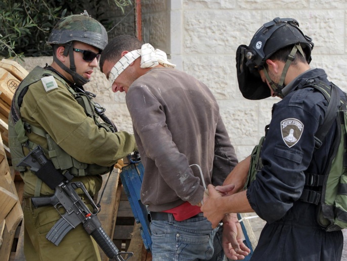 قوة إسرائيلية أثناء اعتقالها شابا فلسطينيا بالخليل جنوبي الضفة الغربية (غيتي/الفرنسية-أرشيف)
