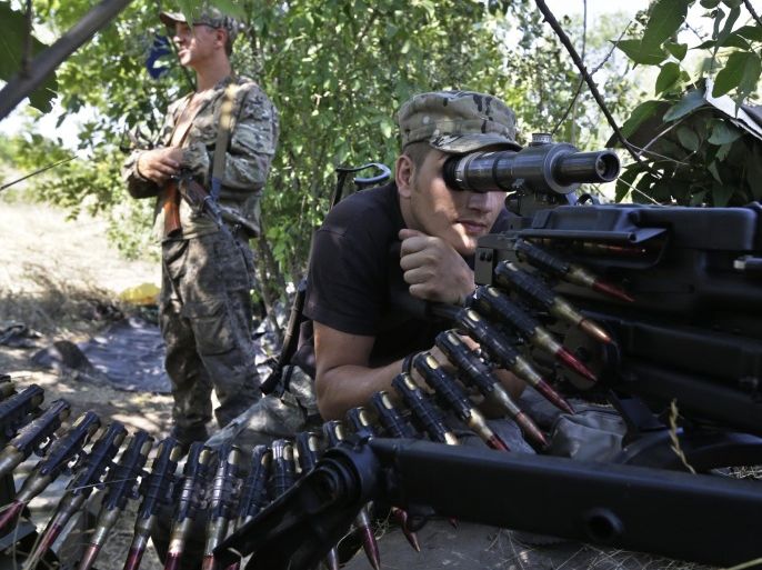 Pro-Russian rebels hold their positions on the frontline near the village of Krasnodon, eastern Ukraine, Friday, Aug. 15, 2014. Russia let Ukrainian officials inspect an aid convoy while it was still on Russian soil Friday and agreed that the Red Cross can distribute the goods in Ukraine's rebel-held city of Luhansk. (AP Photo/Sergei Grits)