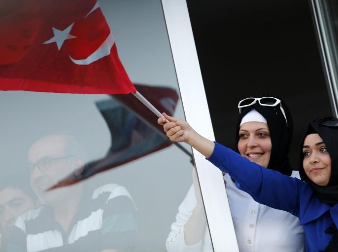 Supporters of Turkey's Prime Minister and presidential candidate Tayyip Erdogan wave portraits of him and Turkey's national flags from the windows of their houses during an election rally in Ankara August 8, 2014. Erdogan is set to secure his place in history as Turkey's first popularly-elected president on Sunday, but his tightening grip on power has polarised the nation, worried Western allies and raised fears of creeping authoritarianism. REUTERS/Umit Bektas (TURKEY - Tags: POLITICS ELECTIONS)