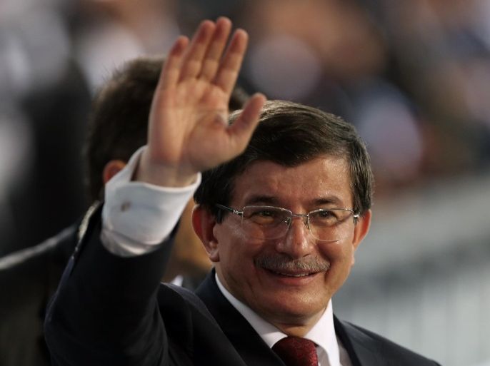Foreign Minister Ahmet Davutoglu salutes cheering supporters after his election during the ruling party congress in Ankara, Turkey, Wednesday, Aug. 27, 2014. Turkey's ruling party is holding a congress to confirm Davutoglu as its new chairman and prime minister-designate, to replace Erdogan. Erdogan on Wednesday rejected claims that Foreign Minister Ahmet Davutoglu, who is set to replace him as prime minister, would merely do his bidding as he continues to rule Turkey from behind the scenes.(AP Photo/Burhan Ozbilici)
