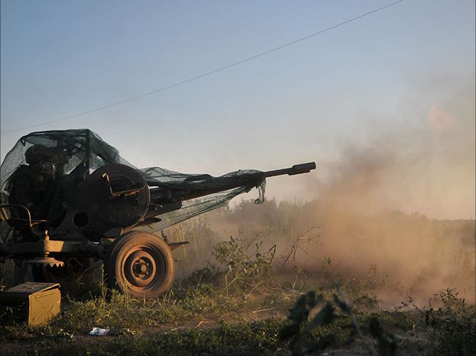 CAPTION CORRECTION CORRECTING BYLINE IN epa04366415 A picture made available on 24 August shows a pro-Ukrainian Donbass battalion fighter firing at pro-Russian rebels with an anti-aircraft gun in Ilovaysk (50km from Donetsk), Ukraine, 23 August 2014. EPA/IVAN BOBERSKYY