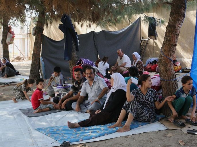 Displaced Iraqis from the Yazidi community gather at a park near the Turkey-Iraq border at the Ibrahim al-Khalil crossing, as they try to cross to Turkey, in Zakho, 300 miles (475 kilometers) northwest of Baghdad, Iraq, Friday, Aug. 15, 2014. The U.N. this week declared the situation in Iraq a "Level 3 Emergency" — a decision that came after some 45,000 members of the Yazidi religious minority were able to escape from a remote desert mountaintop where they had been encircled by Islamic State fighters. The extremist group views them as apostates and had vowed to kill any who did not convert to Islam. (AP Photo/Khalid Mohammed)