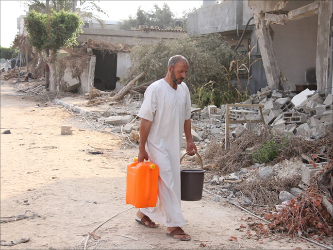 حسن أبو ريدة ينقل المياه التي وفرتها إحدى الجمعيات الخيرية الجزيرة نت)