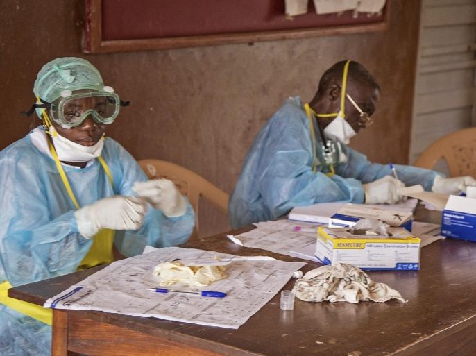 In this photo taken Saturday, Aug. 9, 2014, health worker wearing protective clothing and equipment, out of fear for the deadly Ebola virus, sit at a desk at the Kenema Government Hospital situated in the Eastern Province in Kenema, 300 kilometers, (186 miles) from the capital city of Freetown, Sierra Leone. Over the decades, Ebola cases have been confirmed in 10 African countries, including Congo where the disease was first reported in 1976. But until this year, Ebola had never come to West Africa. (AP Photo/ Michael Duff)