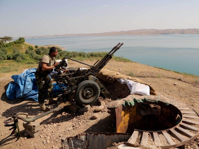 A Kurdish peshmerga fighter prepares his weapon at his combat position near the Mosul Dam at the town of Chamibarakat outside Mosul, Iraq, Sunday, Aug 17, 2014. Kurdish forces took over parts of the largest dam in Iraq on Sunday less than two weeks after it was captured by the Islamic State extremist group, Kurdish security officials said, as U.S. and Iraqi planes aided their advance by bombing militant targets near the facility. (AP Photo/Khalid Mohammed)
