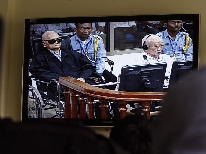 Khieu Samphan, second from right, former Khmer Rouge head of state, and Noun Chea, left, who was the Khmer Rouge's chief ideologist and No. 2 leader, are seen on a screen at the court's press center of the U.N.-backed war crimes tribunal in Phnom Penh, Cambodia, Thursday, Aug. 7, 2014. Three and a half decades after the genocidal rule of Cambodia's Khmer Rouge ended, the tribunal on Thursday sentenced two top leaders of the former regime to life in prison on war crimes charges for their roles during the country's 1970s terror. (AP Photo/Heng Sinith)