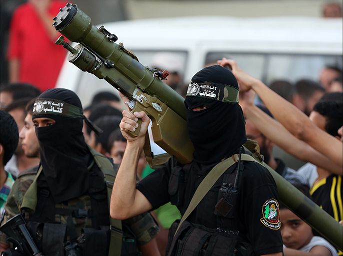 epa04371310 Palestinian fighters of the Ezz Al-Din Al Qassam militia, the military wing of Hamas, pose with weapons in Al-Shejaeiya neighbourhood in the east of Gaza City, 27 Augast 2014. An indefinite ceasefire to end seven weeks of fighting between Israel and Palestinian militant groups in the Gaza Strip was holding 27 August, with Hamas declaring 'victory' and the Israeli cabinet divided on the deal. EPA/MOHAMMED SABER