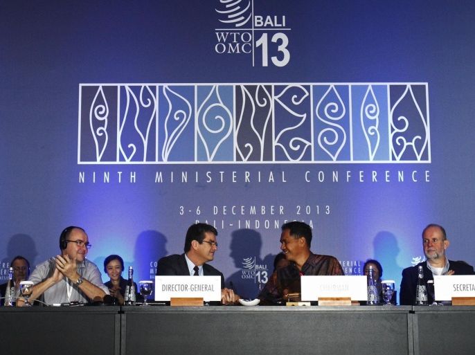 Director-General Roberto Azevedo (centre L) shake hands with Conference Chairman Gita Wirjawan as they declare the ceremonial closing of the ninth World Trade Organization (WTO) Ministerial Conference in Nusa Dua, on the Indonesian resort island of Bali December 7, 2013. The WTO reached its first ever trade reform deal on Saturday to the roar of approval from nearly 160 ministers who had gathered in Bali to decide on the make-or-break agreement that could add $1 trillion to the global economy. REUTERS/Edgar Su (INDONESIA - Tags: POLITICS BUSINESS)