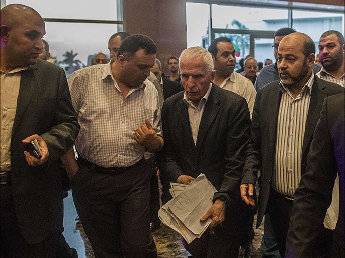 Head of the Palestinian delegation Azzam al-Ahmed (C) and Hamas deputy leader Musa Abu Marzuk (R) arrive upon at the hotel after a meeting with Egyptians seniors intelligence in Cairo on August 13, 2014. Egyptian mediators raced to bridge gaps between Palestinians and Israelis as they struggled to secure a lasting Gaza truce ahead of the midnight expiry of a three-day ceasefire, an official said. AFP PHOTO / KHALED DESOUKI