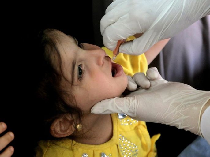 An Iraqi doctor gives a polio vaccine to a child in Baghdad, Iraq, Wednesday, May 14, 2014. With the assistance of international health organizations, Iraqi health officials are scrambling to vaccinate millions of children across Iraq against the highly contagious polio virus in response to the outbreak of the disease in the country as well as the region, a spillover from the three-year-old war in neighboring Syria where a handful of children have been affected. (AP Photo/ Khalid Mohammed)